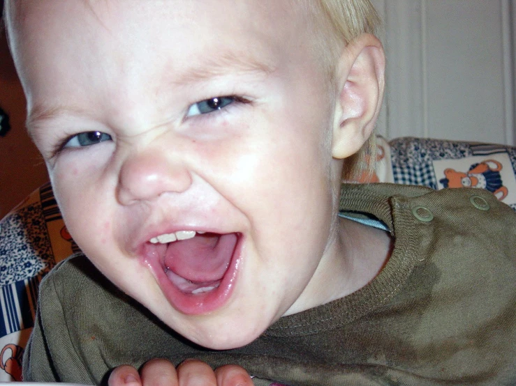 a baby has his tongue out to make a face