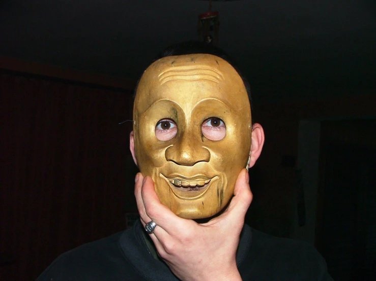 a person wearing a mask with one hand on his face