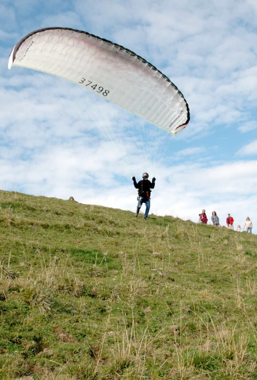 a person in full parachute with hands up flying in the sky