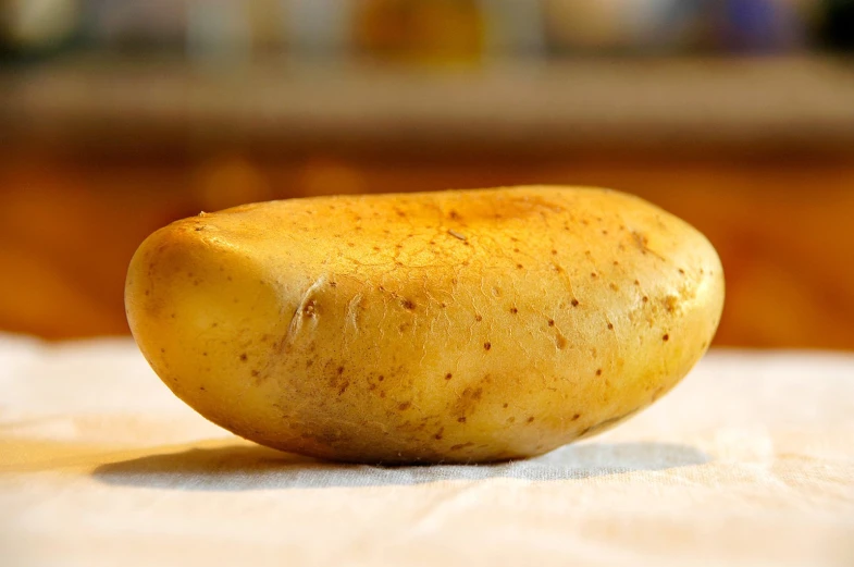 a rotten potato laying on a white table cloth