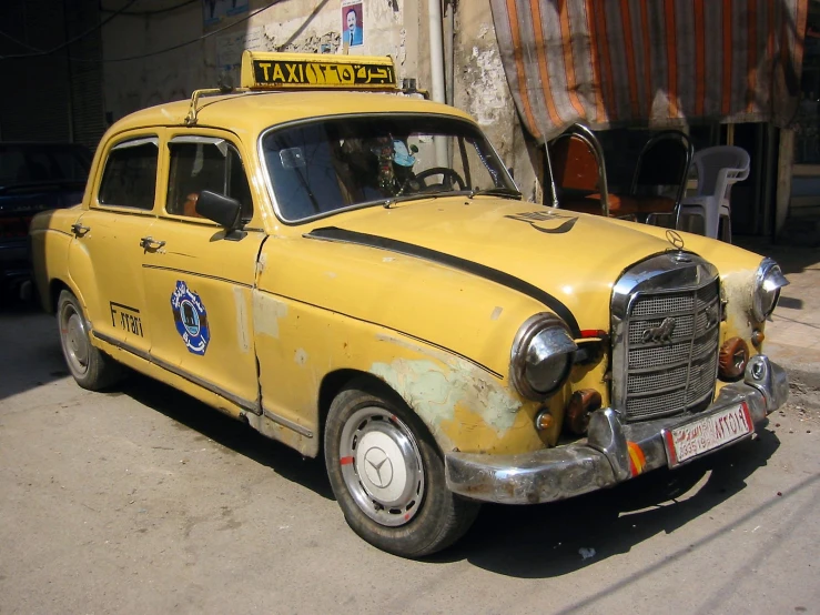 a yellow taxi sits parked on a city street