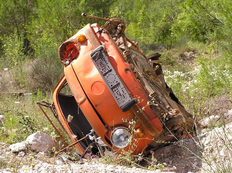 an old car that is rusted in some kind of junkyard