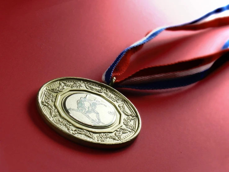 a close up of an olympic medal with ribbon