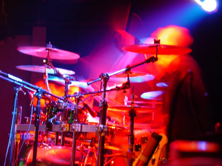 a drummer plays in front of colored light