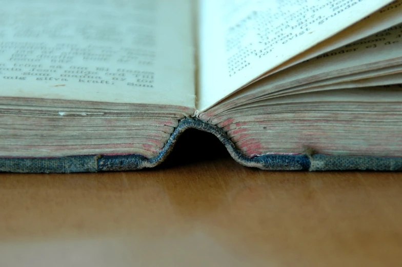 the open book with pages pulled up on top of a table