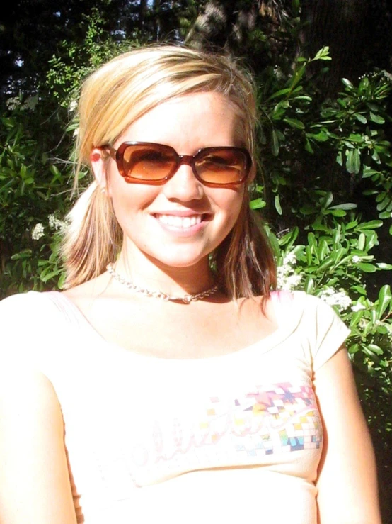 a girl with glasses and sunglasses smiling at the camera