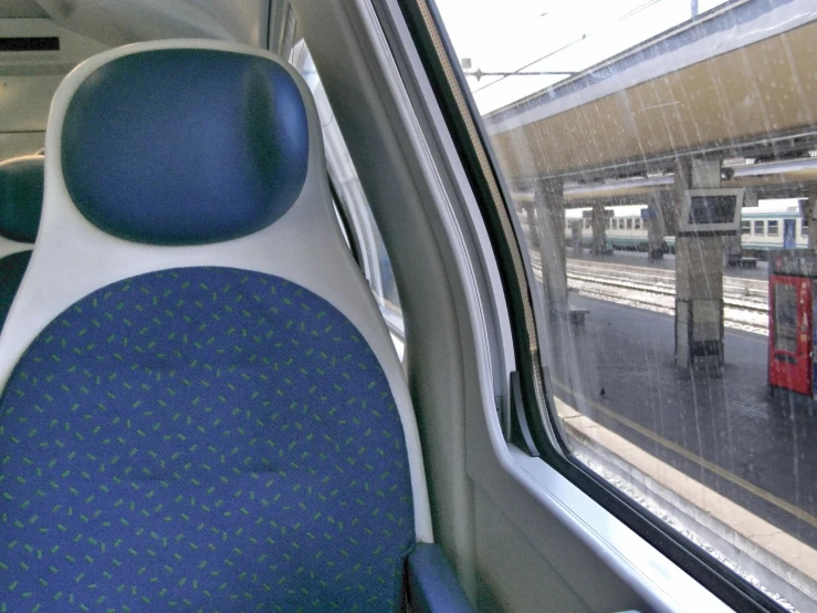 the inside of an empty train looking at another train