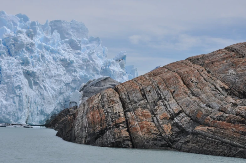 an iceberg in the middle of a lake with water and rocks