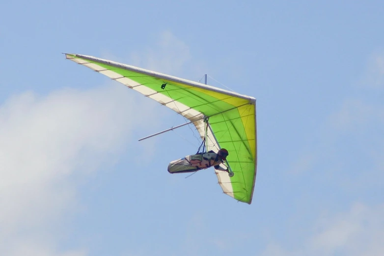a man is flying a green sail through the air