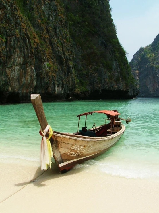 a long wooden boat on the beach at low tide