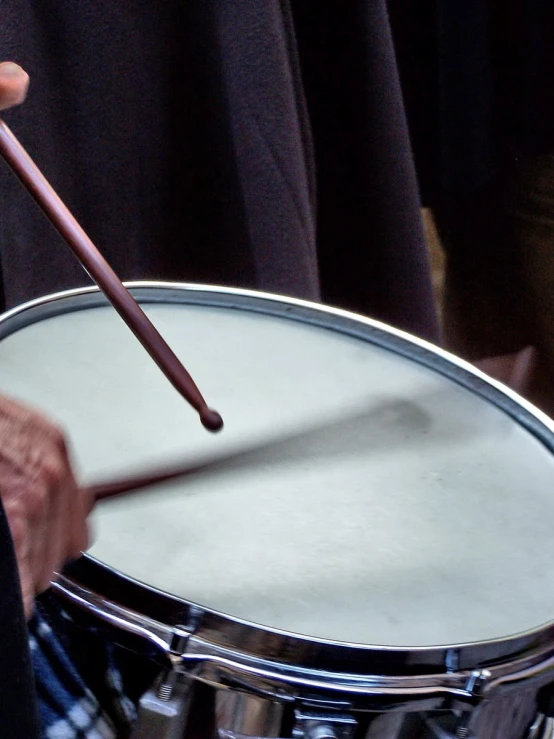 a person is playing on a metal drum