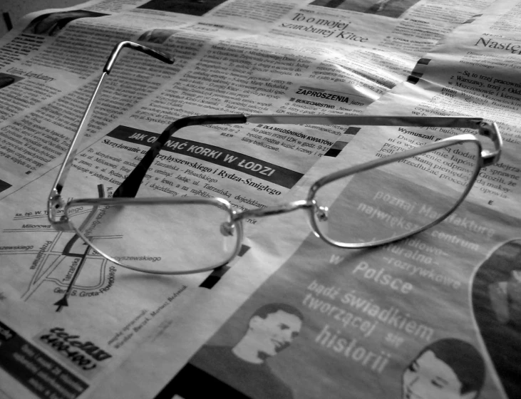 a pair of glasses resting on top of news paper