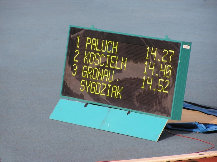 a tennis court with a sign on it and the date in english