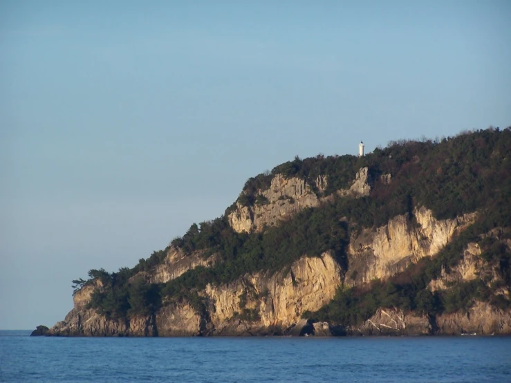 a boat is in the water near a large rock