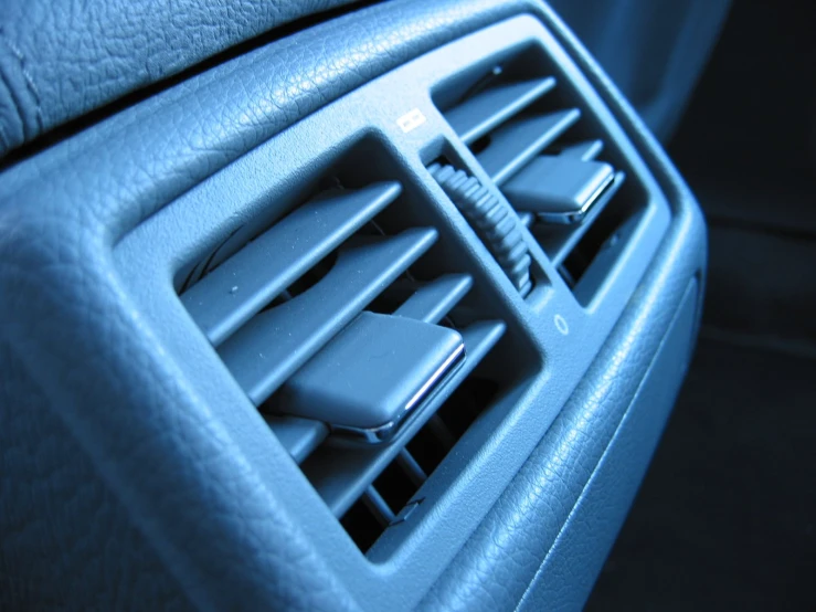 the air vent of an empty car with remote controls