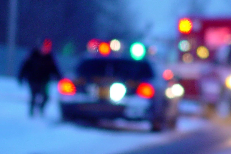 some cars lights trees and snow and people