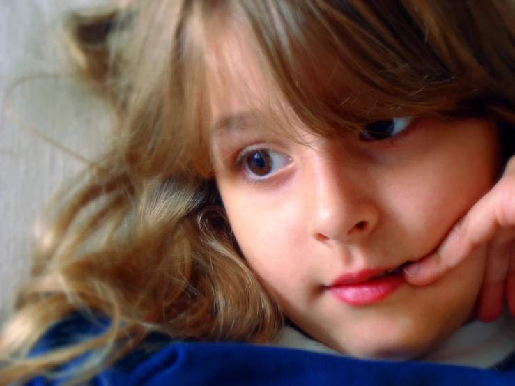 a little girl with big blue eyes posing for the camera