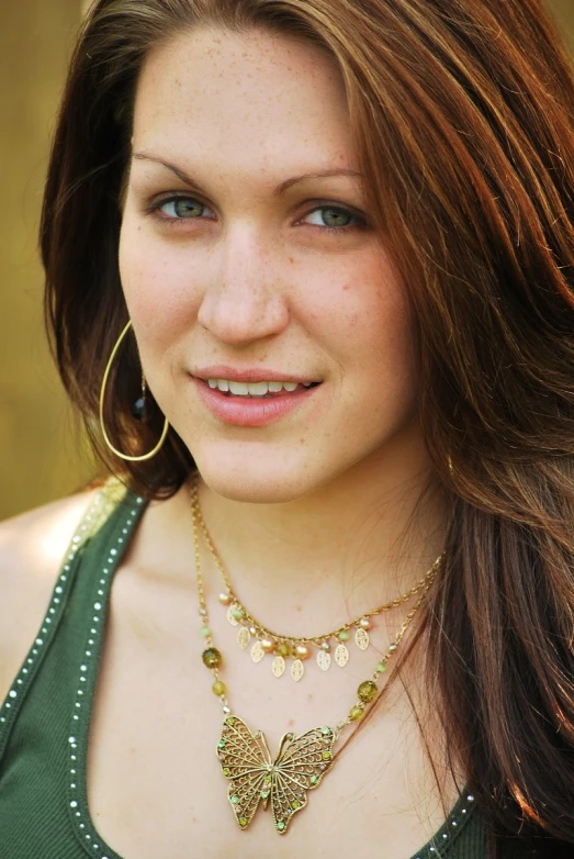 a woman wearing gold plated necklace and earrings