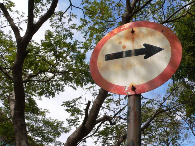 an old and rusty street sign on a metal pole