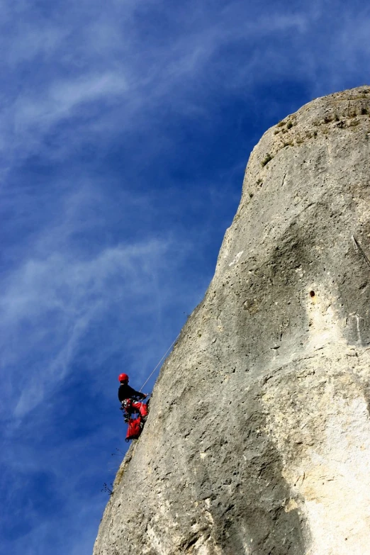 a person standing on the side of a cliff