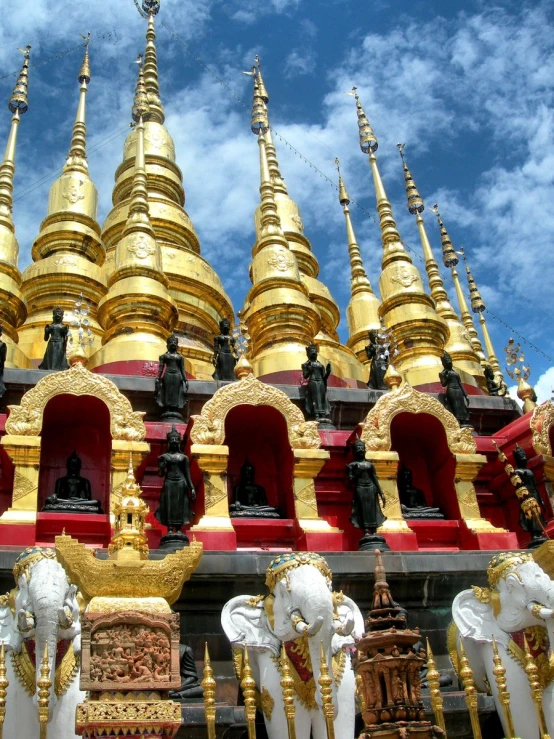 a golden building with statues and gold pillars under a blue sky