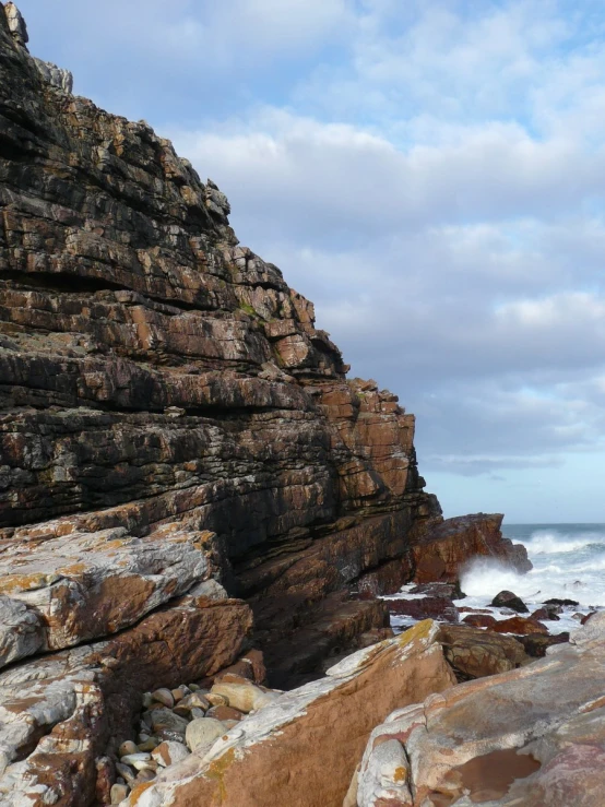 a cliff face with water crashing into it