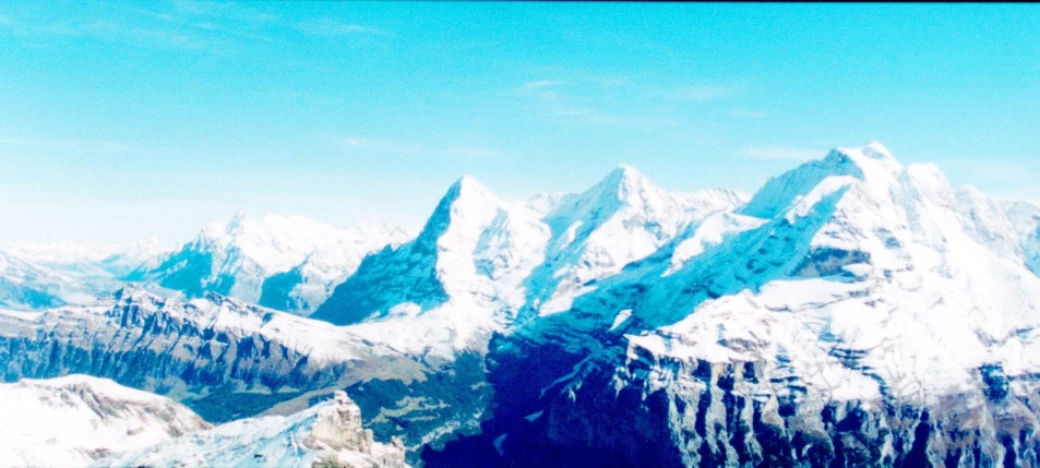 the top of snowy mountain tops under blue skies