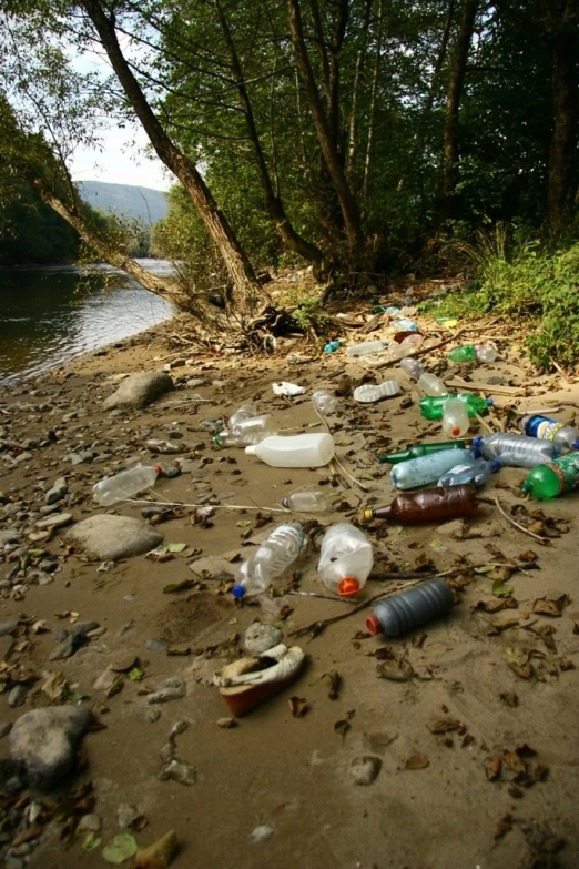 trash is strewn on the ground near water