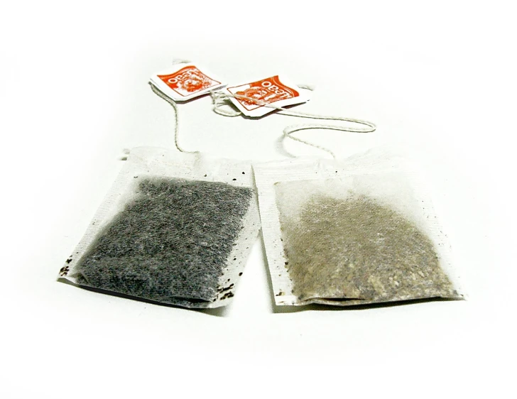 two bags of dust on white table with one bag of sand