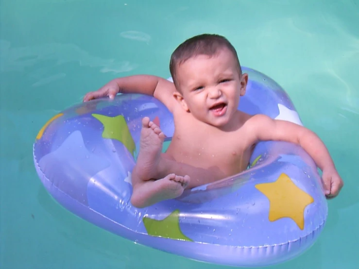 a toddler floating on a raft in the pool