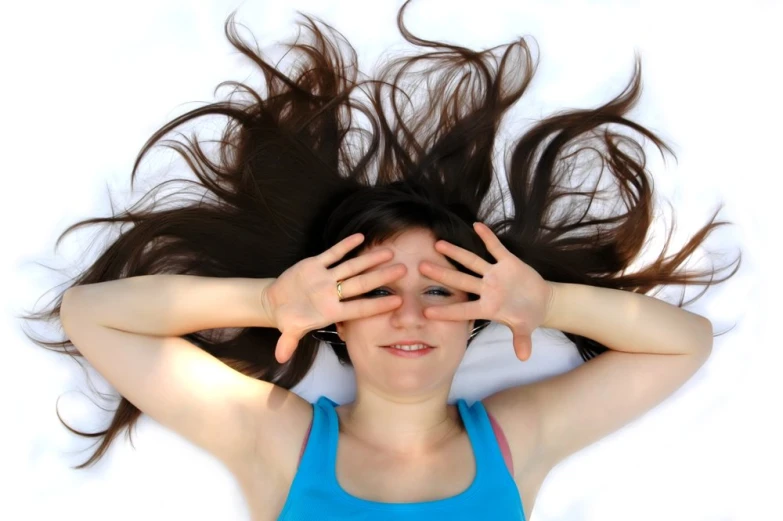 a young lady holding her hair in front of her face