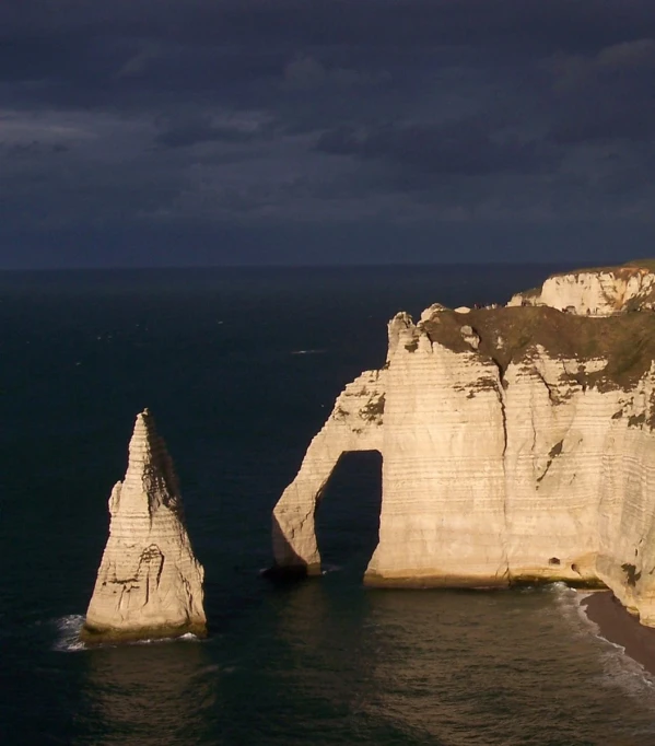 the two large rocks stand tall in front of the ocean