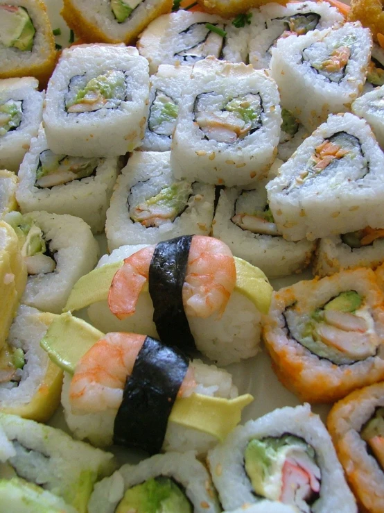 assorted pieces of sushi are stacked close together