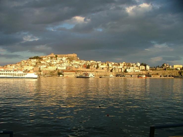 boats moored and a city by the shore with stormy skies