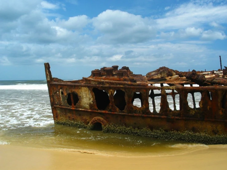 rusty wreck ship laying on shore near ocean