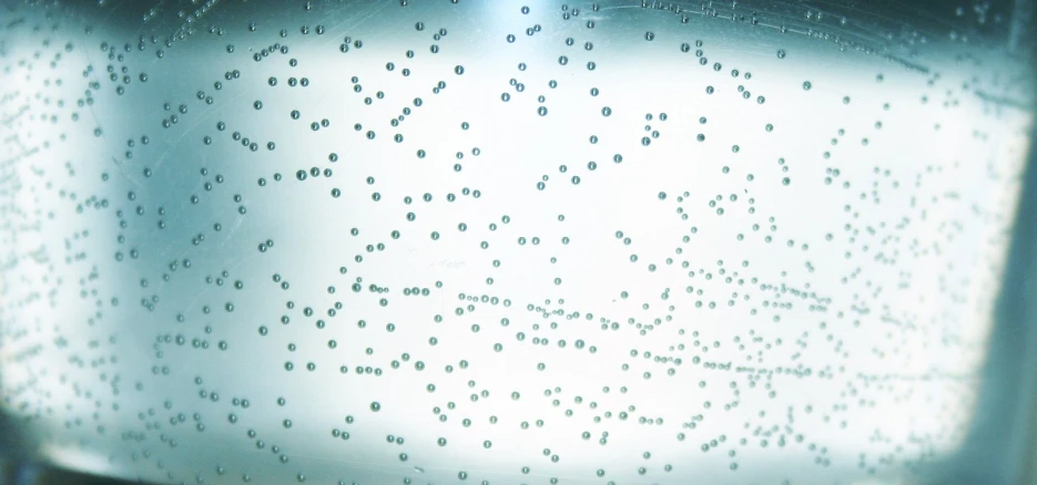 a large glass jar with a number of water drops on it