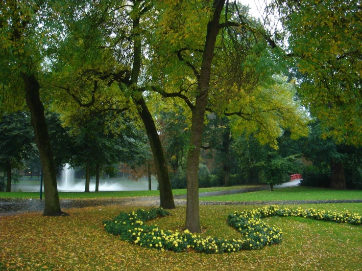 a lush green park with trees, flowers and benches