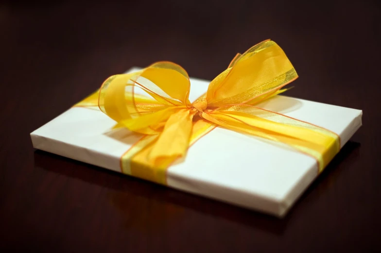 an orange and yellow bow sits on a white box