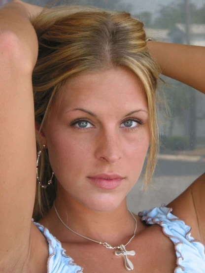 a young lady in a blue top posing for the camera