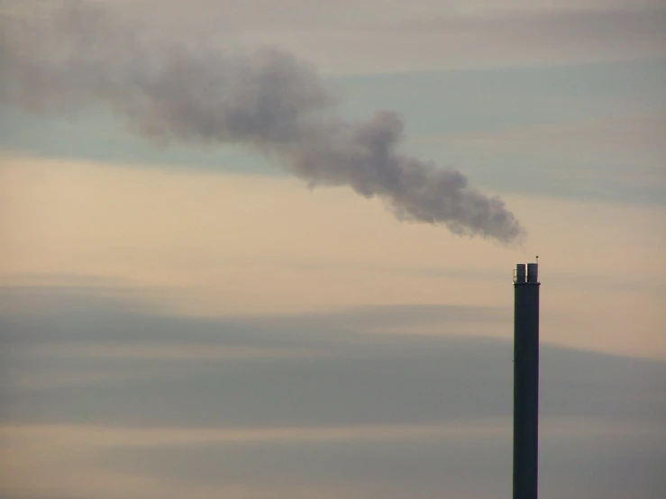 smoke coming from a chimney billowing from a tall building