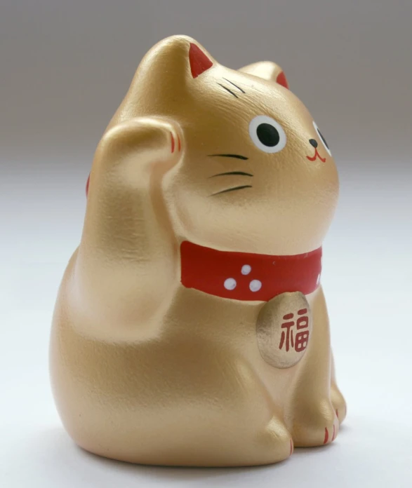 a cat figurine that is yellow and red