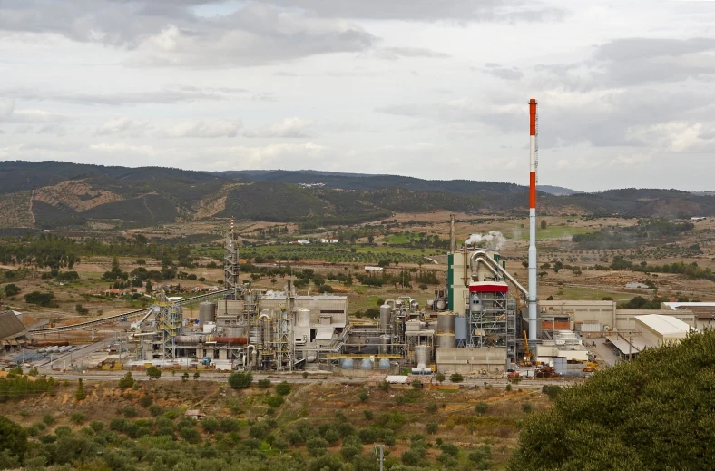 large factory with mountains in the background in an arid landscape