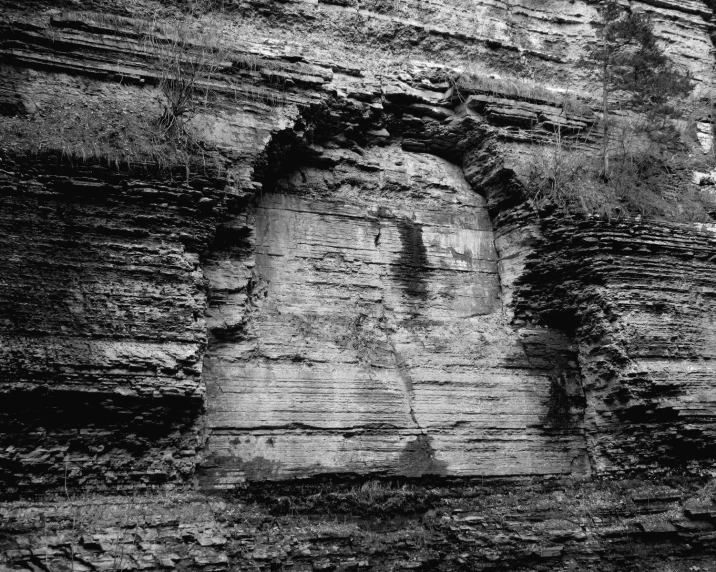 a person is standing at the base of a cliff