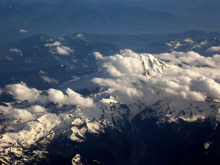 the view from an airplane looking down at some mountains and clouds