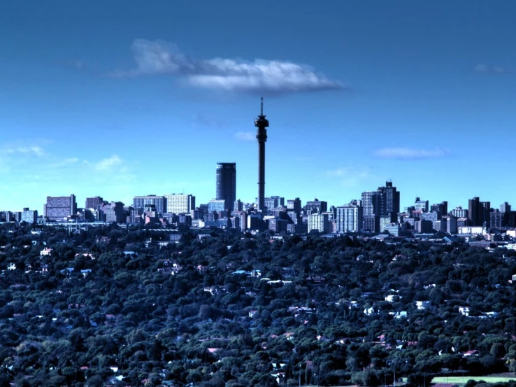 the tall tower is overlooking the city from the top of the hill