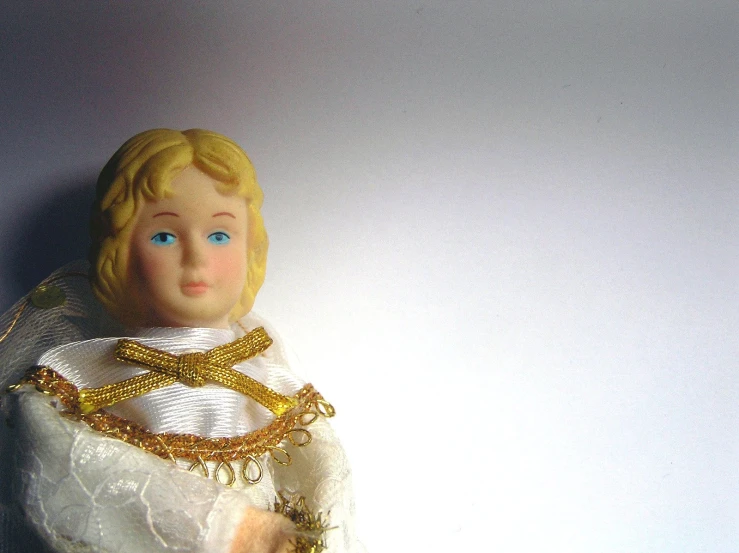a doll with blonde hair wearing a white wedding dress