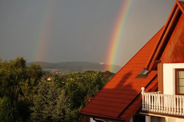a rainbow is seen in the distance above a house