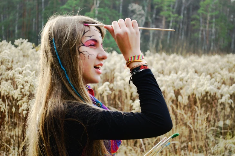  with makeup paints posing in tall grass