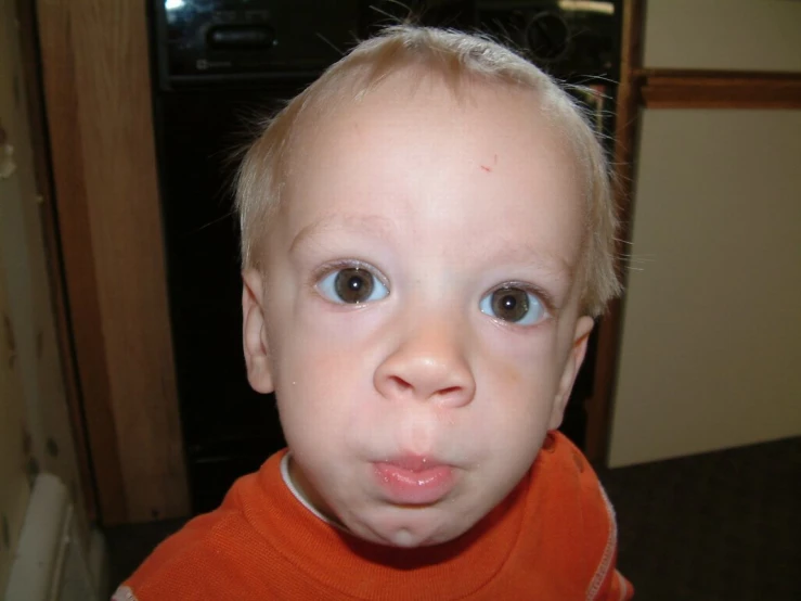 a toddler has big eyes and looks into the camera