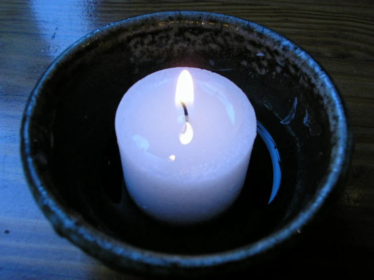a single candle on top of a black plate